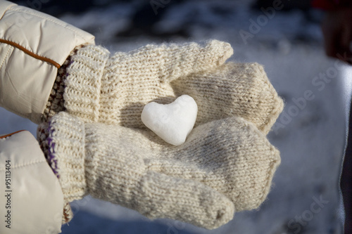 ice in the form of heart in his hands in gloves closeup