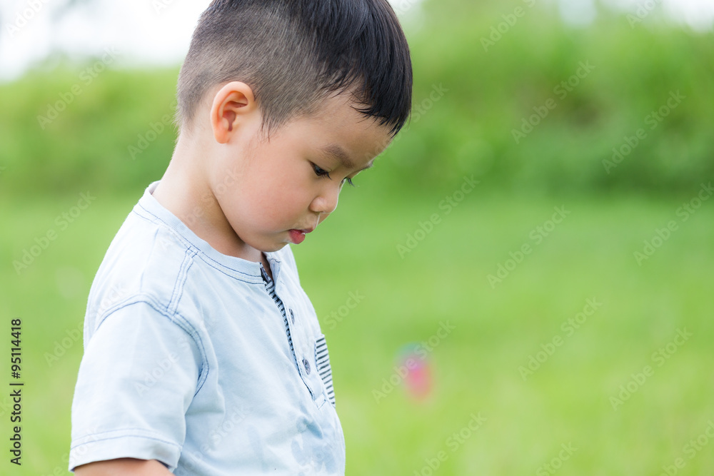 Little boy feeling unhappy and looking down Little boy feeling unhappy and looking down