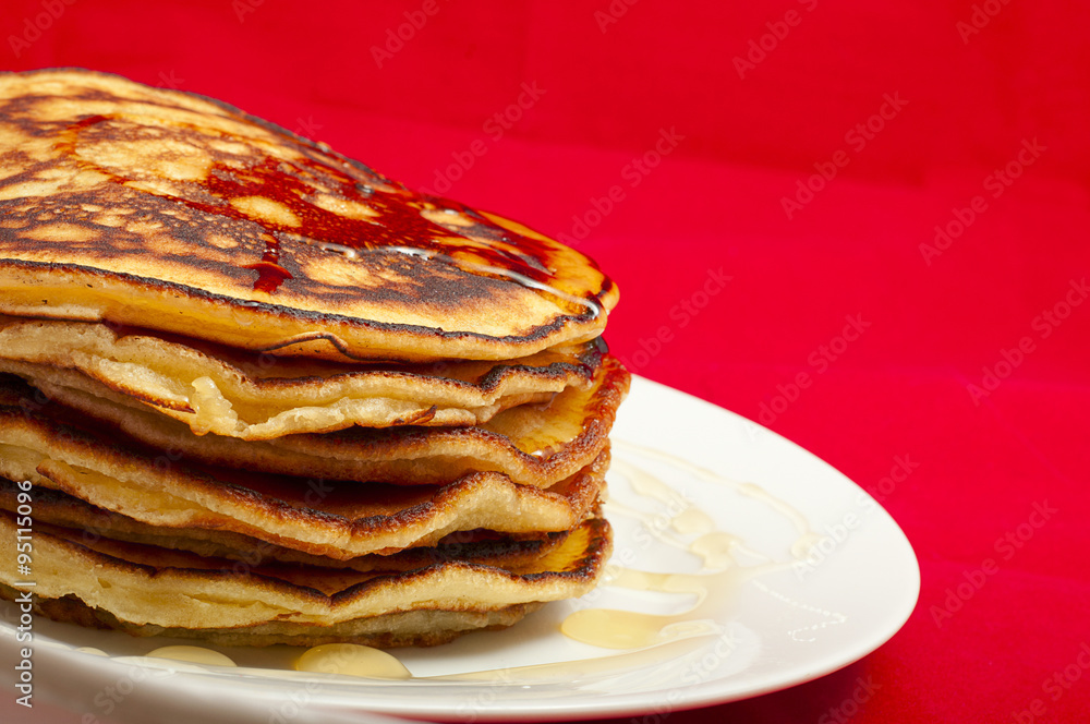 delicious pancakes with honey sauce on red background delicious pancakes with honey sauce on red background