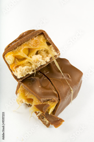 two slices of Snickers bars on a white background macro photo