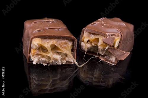 two slices of Snickers bars on a black background macro photo
