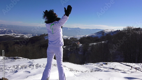 Hands raised Girl on the snow mountain  photo