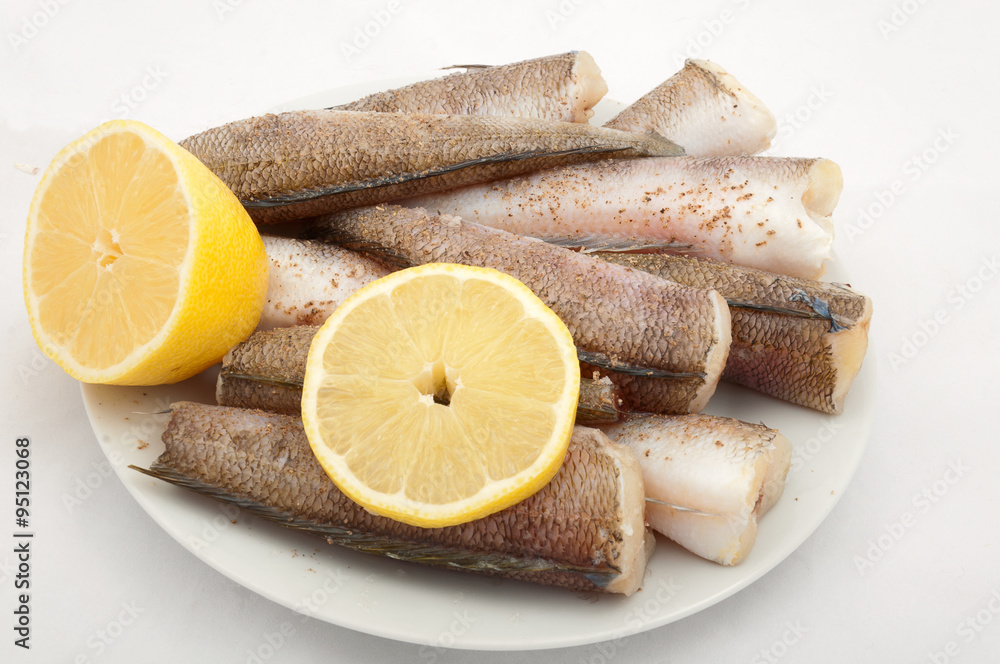 fish ready for cooking with spices ànd lemon on a plate on white fish ready for cooking with spices ànd lemon on a plate on white