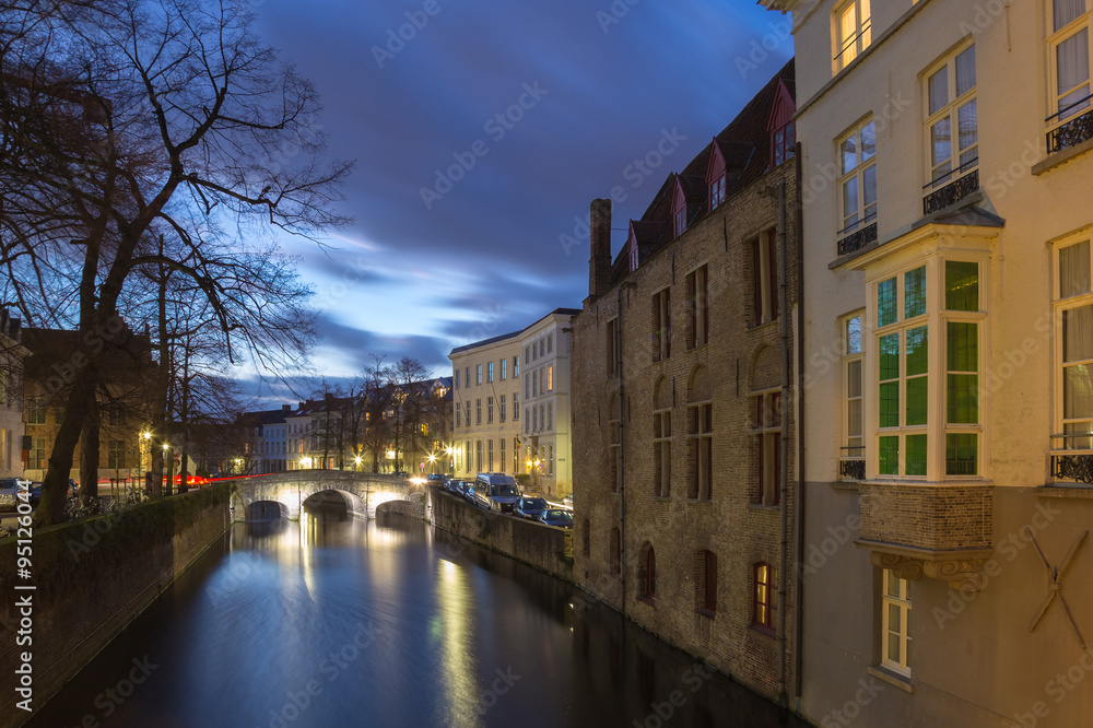Obraz premium Bruges canal view with bridge, tree and houses at blue hour, Belgium