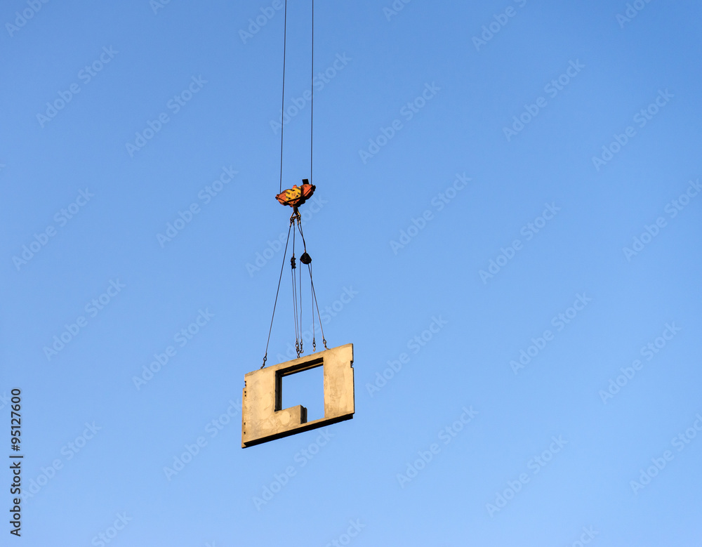 A crane lifts the concrete panel