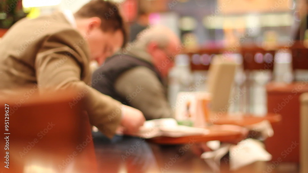 Two men read newspapers in cafe Two men read newspapers in cafe