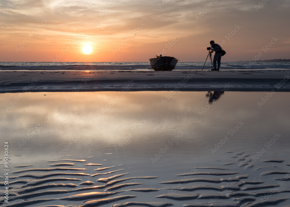 Photographer shooting the Boats at the beach during sunset