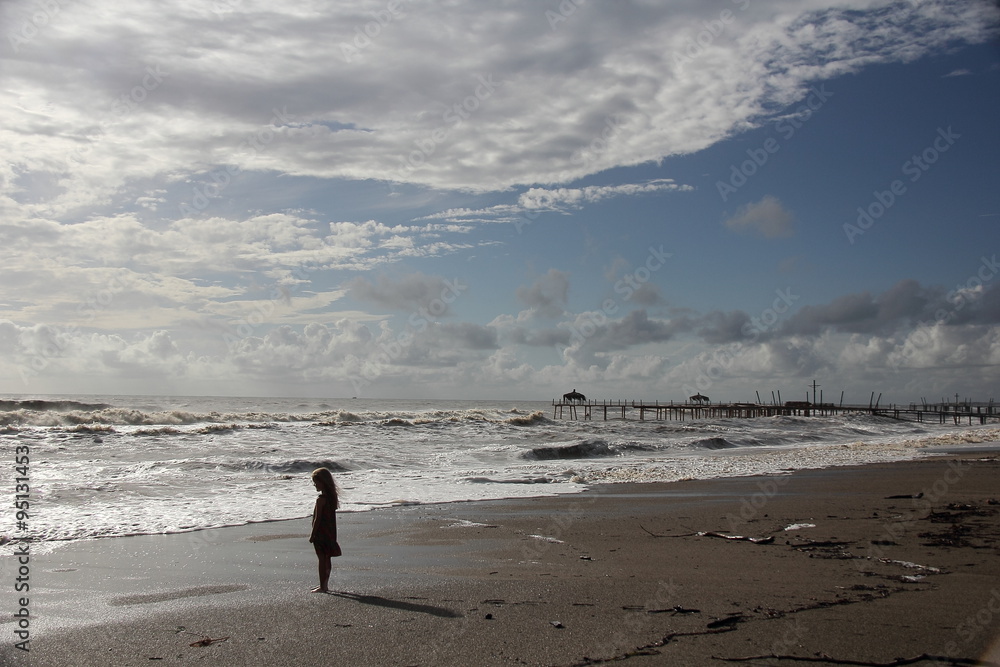Little girl looks over the large, wide sea