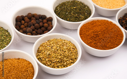 Different spices in white dishes