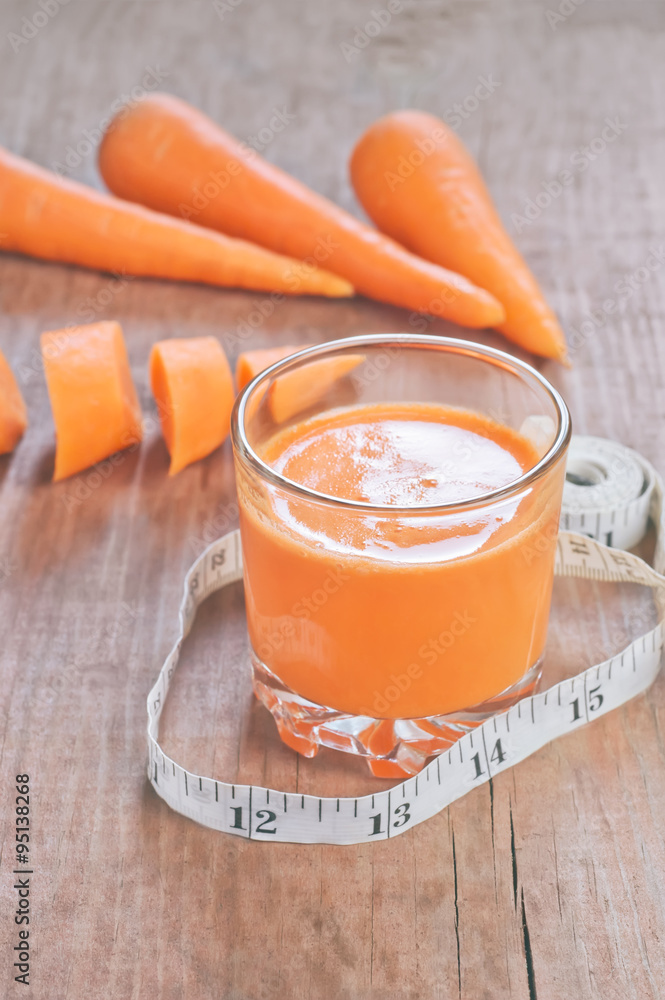 Glass of homemade juice, carrots and centimeter on wooden board Glass of homemade juice, carrots and centimeter on wooden board