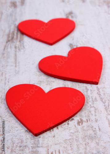Valentine red hearts on old wooden white table, symbol of love