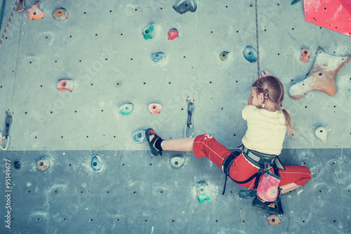 little girl climbing a rock wall