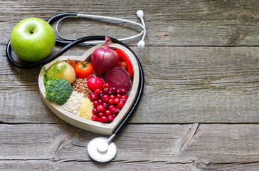 Healthy food in heart and cholesterol diet concept on vintage boards

