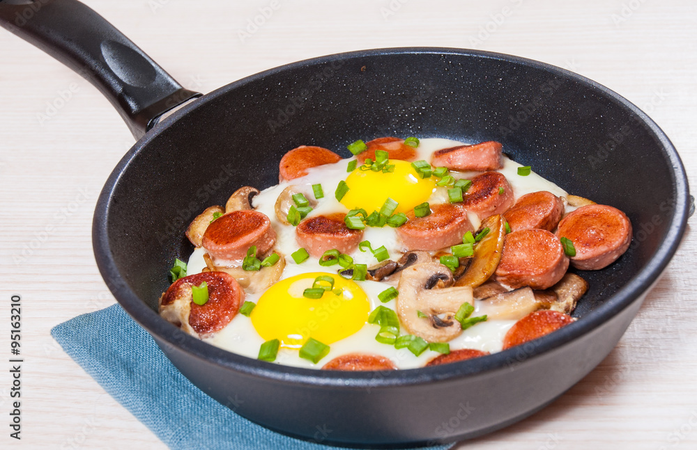 fried eggs with mushrooms and sausage in a frying pan fried eggs with mushrooms and sausage in a frying pan