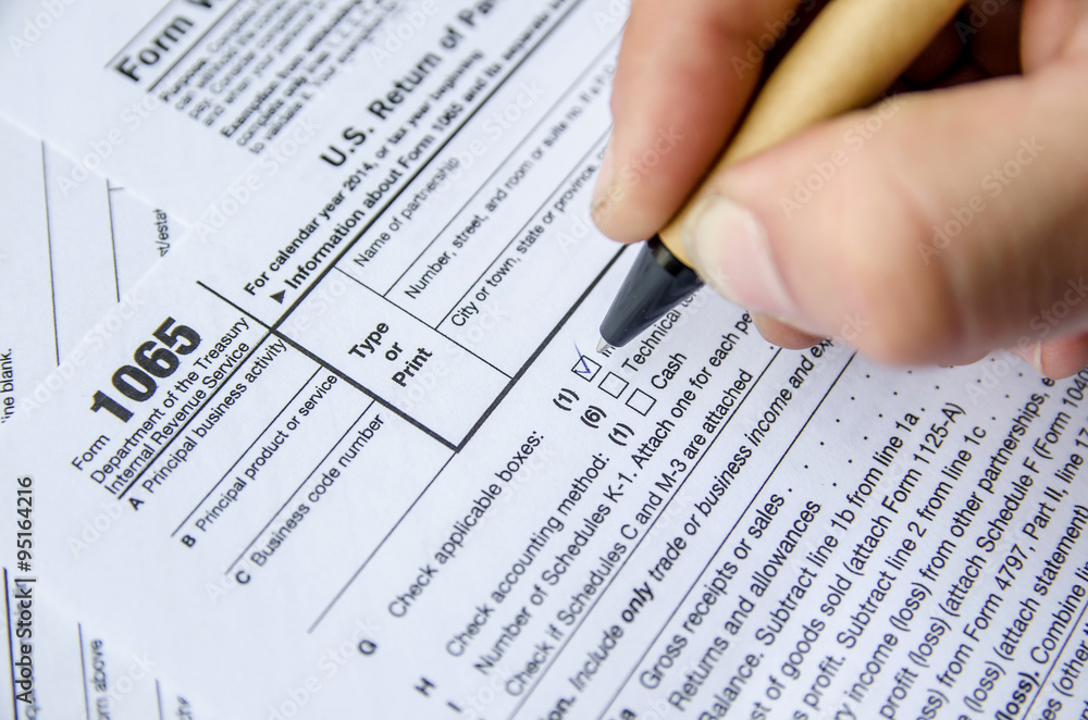 Fototapeta premium Person completing 1065 tax form