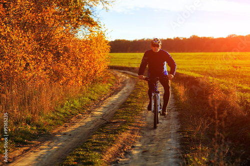 young adult cyclist riding mountain bike in the countryside © Aleksey
