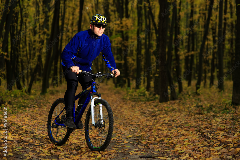 Obraz premium young adult cyclist riding mountain bike in the countryside