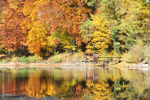 Herbst an einem See mit Fischerhütten