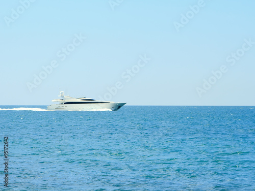Luxury white speed yatch in open waters full ahead