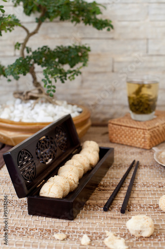 Traditional asian sesame cookies in a wooden box, green tea © annapustynnikova