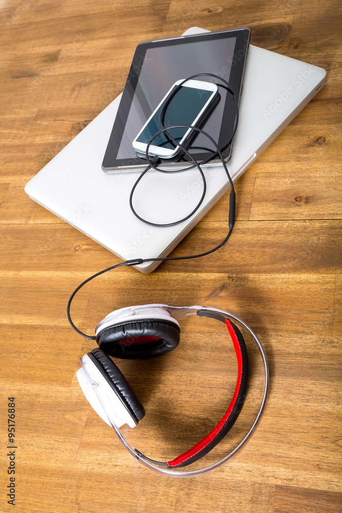 Digital devices and Headphones on a wooden Desktop. Digital devices and Headphones on a wooden Desktop.