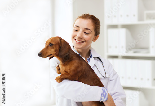 Fotografia happy doctor with dog at vet clinic