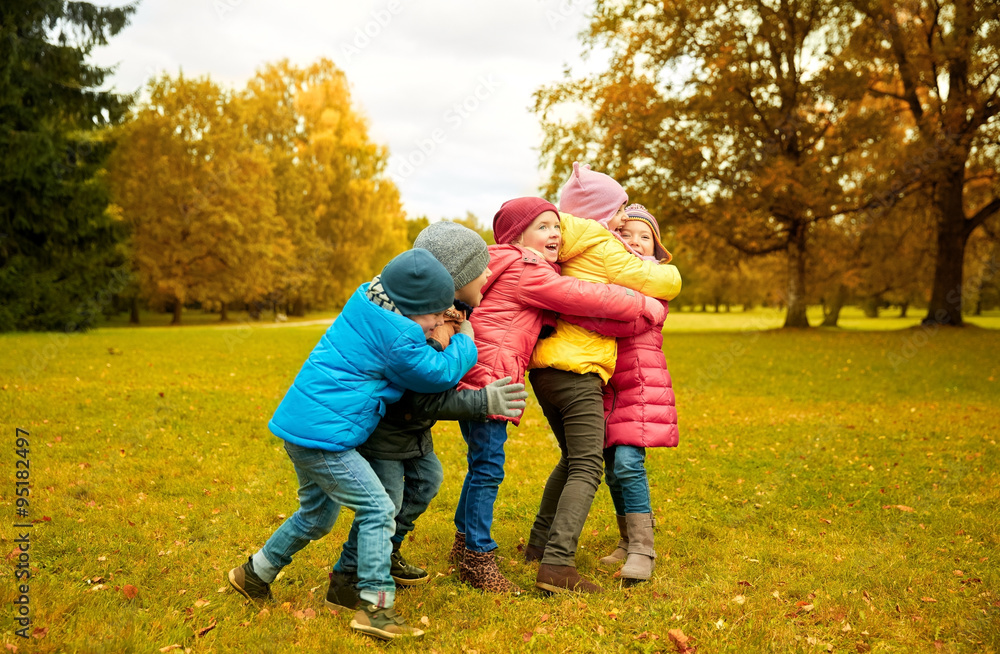 group of happy children hugging in autumn park group of happy children hugging in autumn park