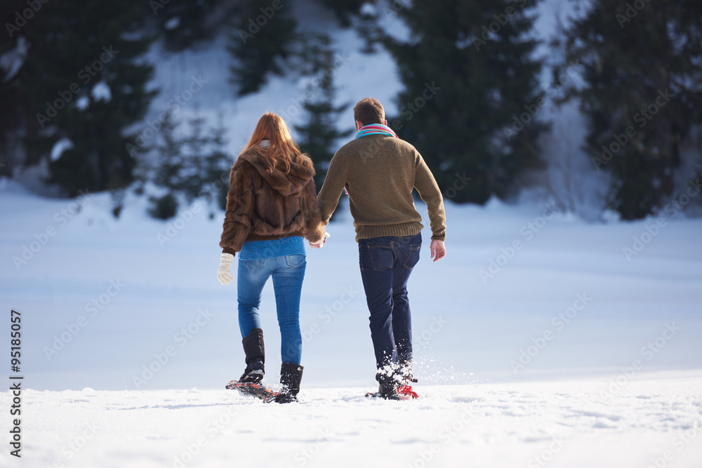 couple having fun and walking in snow shoes couple having fun and walking in snow shoes