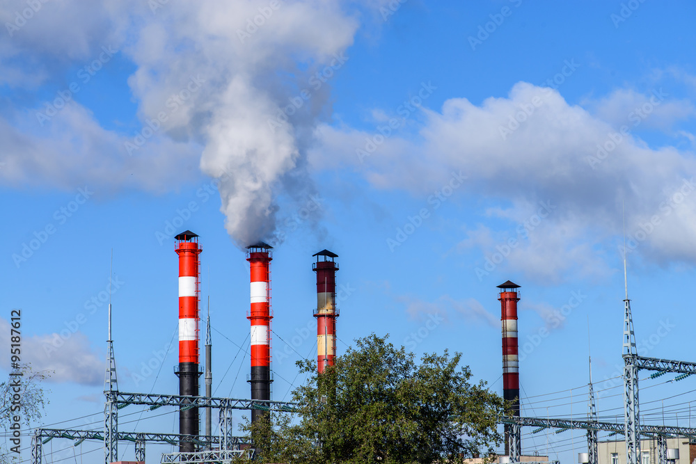 plant pipe with smoke against blue sky