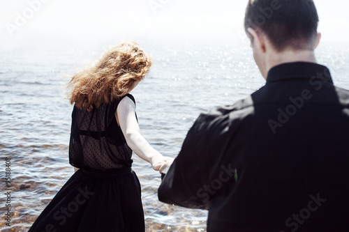 beautiful young couple hugging standing in the sea, photo colorization effects