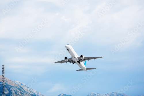 Aircraft take off. Mountains view. Passenger airplane in the sky.