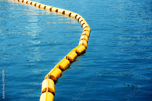 Border of swimming area marked with line of yellow plastic buoys.