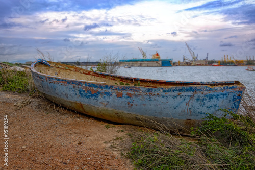 Old derelict boat on pebble beach.