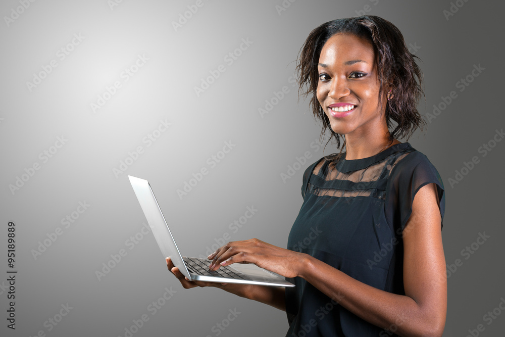 Portrait of confident young african woman using laptop