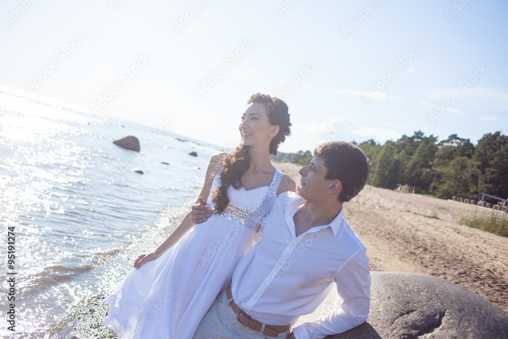 Just married happy bride and groom, young couple embraces on the beach Just married happy bride and groom, young couple embraces on the beach