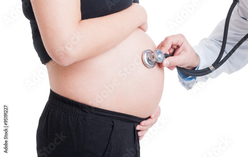Doctor listening pregnant woman belly using stethoscope