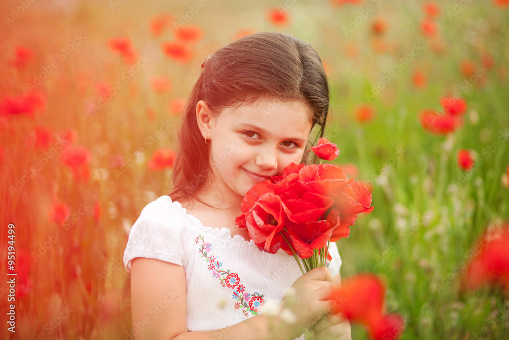 Closeup of cute girl in poppy field holding flowers bouquet outdoors. Girl in poppies. Happy kid with poppies. Closeup of cute girl in poppy field holding flowers bouquet outdoors. Girl in poppies. Happy kid with poppies.