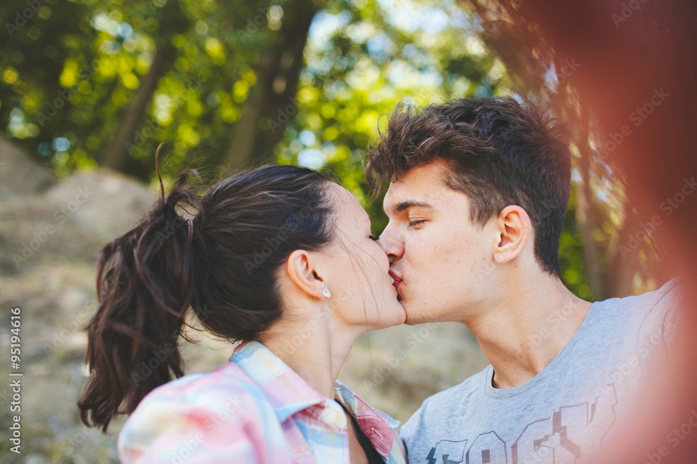 Loving couple of teenagers kissing. Hipsters love. Young man kissing his girlfriend. Loving couple of teenagers kissing. Hipsters love. Young man kissing his girlfriend.