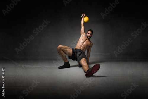 trainer lying down with kettlebell on hand