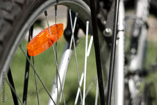 Bright orange reflector on the bicycle wheel. Shallow DOF