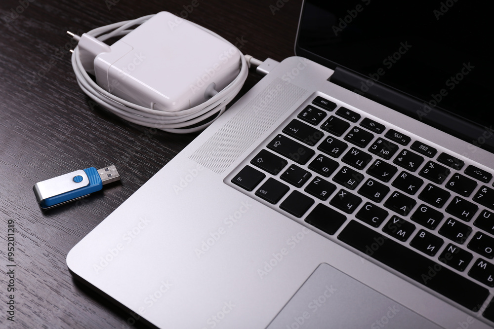 Close-up view of laptop and equipment at working place on black wooden background