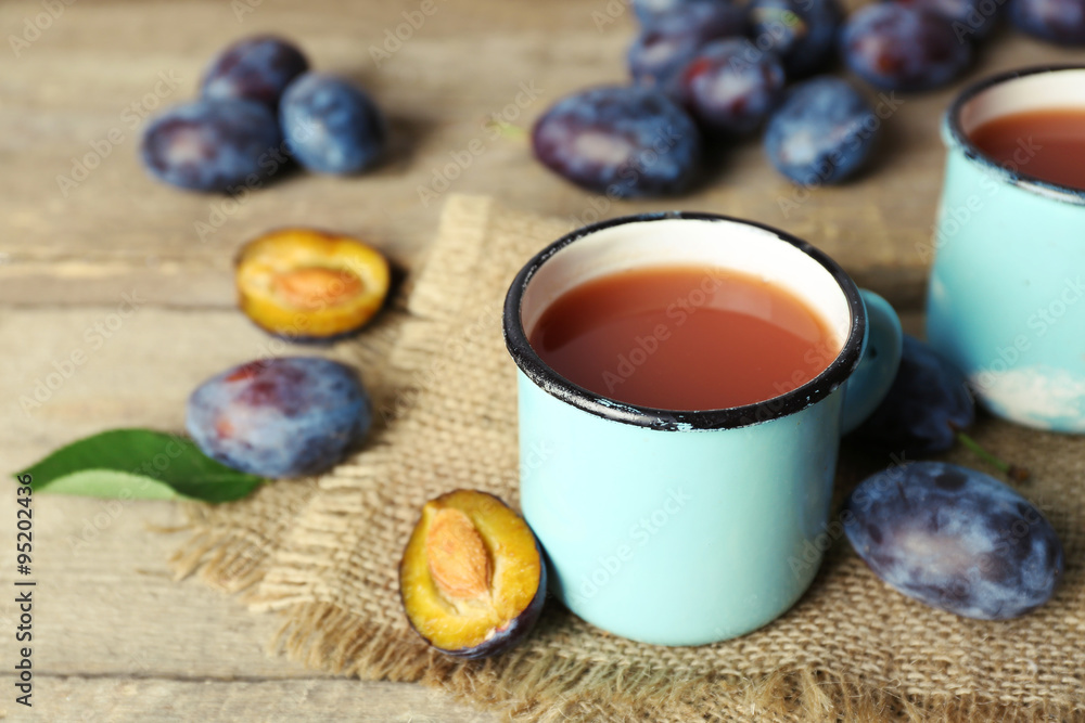 Plum Juice in mugs with fresh fruits Plum Juice in mugs with fresh fruits