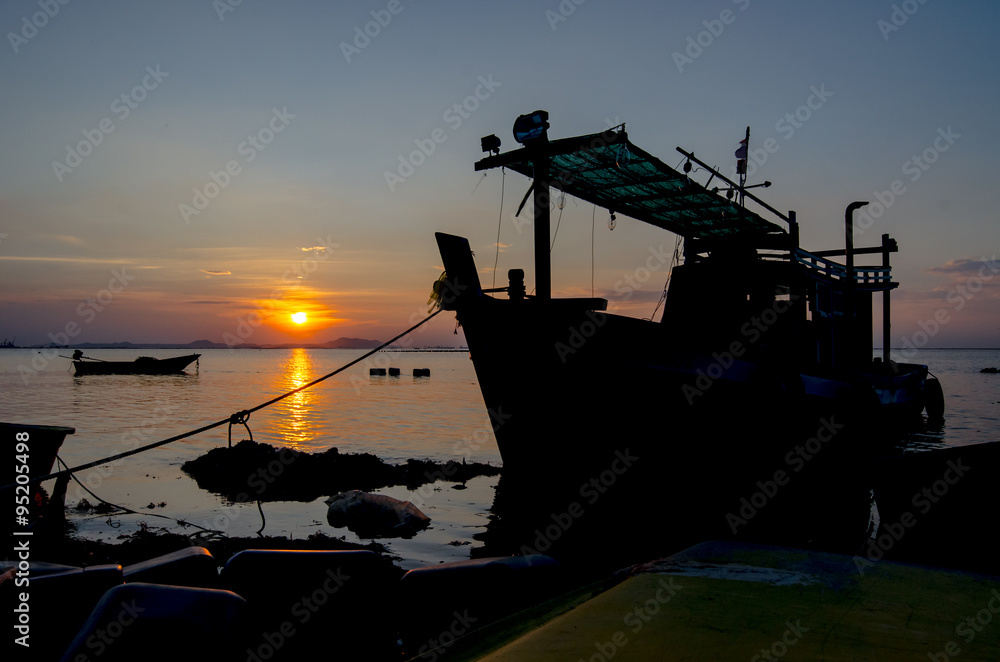 Silhouette of ship with sunset sky at sea