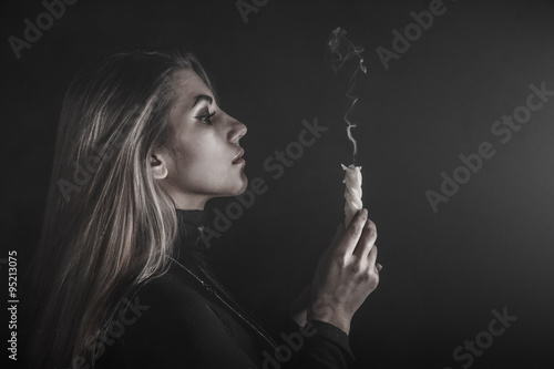 Valokuvatapetti Young woman holding a candle in a smoke