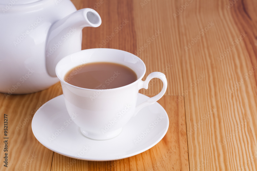 Cup of traditional English Tea with white china teapot