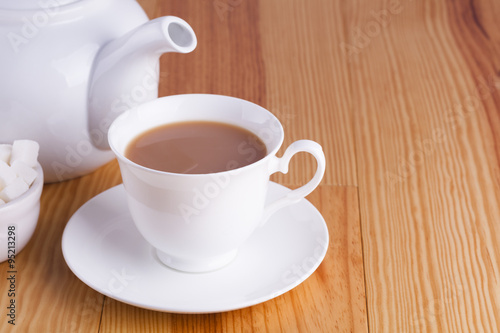 Cup of traditional English Tea teapot and sugar lumps