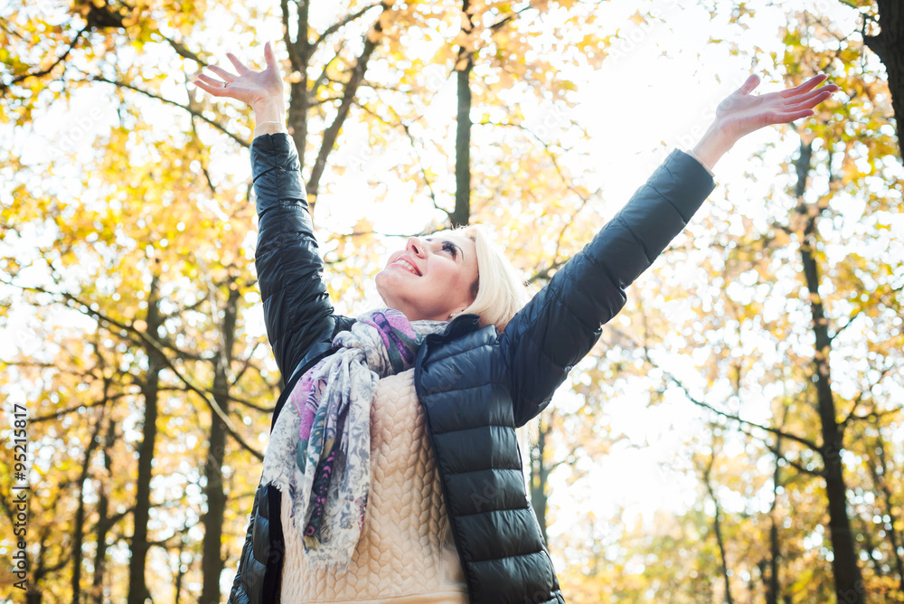 young happy woman with cheering hands in park. Female enjoying autumn sun young happy woman with cheering hands in park. Female enjoying autumn sun