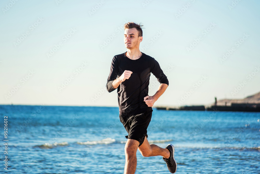 Running man. Male runner jogging during the sunrise on beach Running man. Male runner jogging during the sunrise on beach