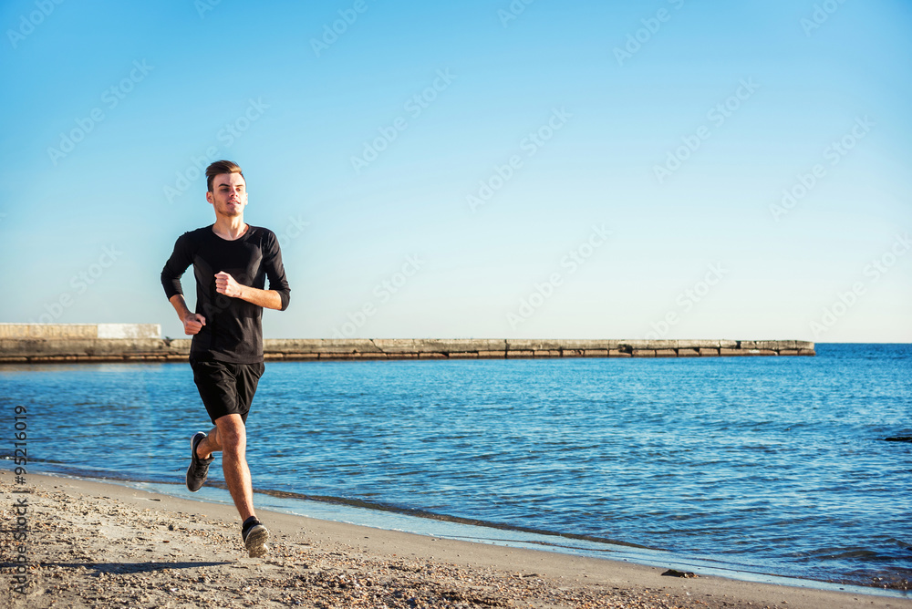 Running man. Male runner jogging during the sunrise on beach Running man. Male runner jogging during the sunrise on beach