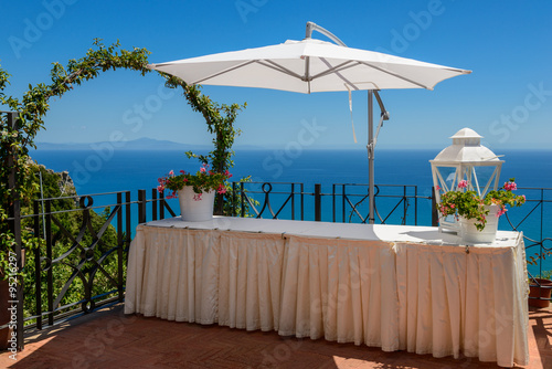 Mediterranean seascape with a table and sun-shade.
